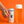 Hand holding a can of East Forged nitro white tea & calamansi citrus with Saka cat on the front.  Glass of poured tea and nitro foam beside the can. Bright orange background.